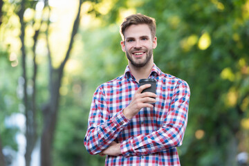 Naklejka na ściany i meble smiling young man in checkered shirt with coffee cup