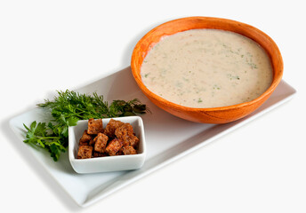 Сreamy soup with spices and crackers on a light background