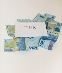 Indonesian money IDR in the envelope with THR text. THR is holiday allowance in iedul fitri or lebaran