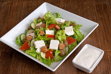 Greek salad with fresh vegetables, feta cheese, green olives and rusks.