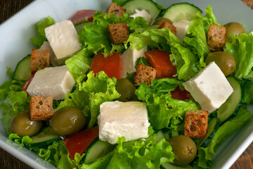Greek salad with fresh vegetables, feta cheese, black olives and rusks.