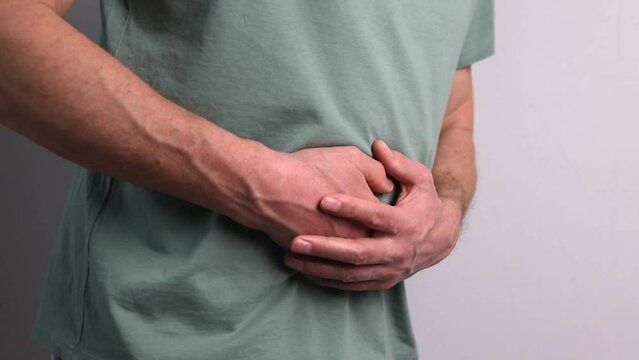 Man suffering from stomachache and holding hands on stomach. Health and medicine concept. Indigestion, inflammation.