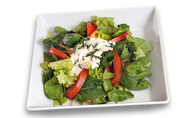 Green vegan summer lettuce with spinach, by tomatoes and sour cream. Healthy food concept.