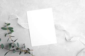 Wedding stationery invitation card mockup 5x7 on neutral grey stone background with eucalyptus...
