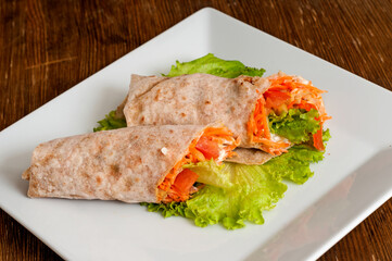 Pita bread wrapped with vegetables and sour cream.