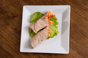 Pita bread wrapped with vegetables and sour cream.