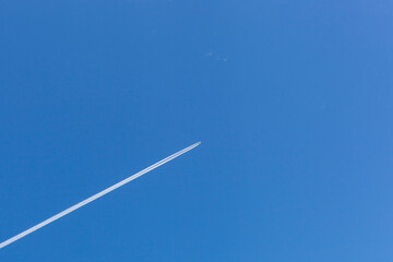 An airplane moving over the blue sky background