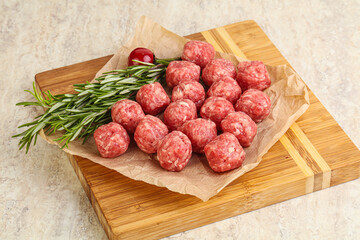 Raw uncooked beef meatballs served rosemary