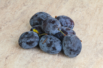 Ripe plum heap over background