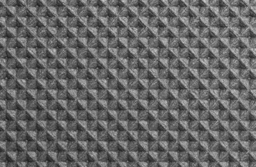 A geometric pattern of foamed polyurethane mat in shades of gray with silver highlights