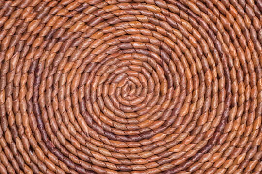 The curled up pattern of brown-colored straw placemat