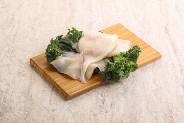 Raw squid over wooden board