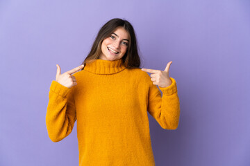 Young caucasian woman isolated on purple background giving a thumbs up gesture