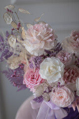 Beautiful composition with peonies and roses in a purpl box on pink chair. Bouquet of tenders peonies a girl for mother's day, valentine's day, Woman's day 8 march.