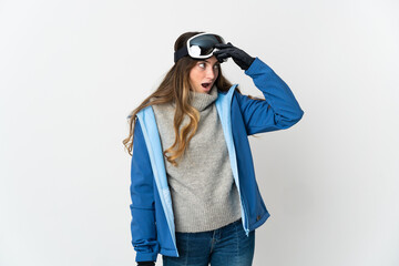 Skier girl with snowboarding glasses isolated on white background doing surprise gesture while looking to the side