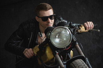 Motorbiker in the black leather jacket is riding the the old motorbike concept. Custom bike.