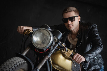 Fototapeta na wymiar Motorbiker in the black leather jacket is riding the the old motorbike concept. Custom bike.