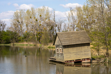 Obraz premium Small wooden house in the forrest, on the river.