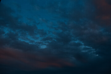 Naklejka na ściany i meble Natural landscape of dark cloudy sky at sunset.