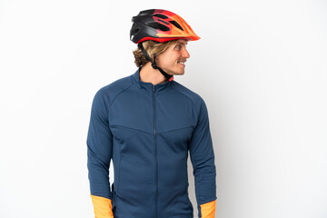 Young blonde cyclist man isolated on white background looking side - obrazy, fototapety, plakaty