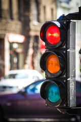 Pedestrian traffic light on the street junction in the city with beautiful bokeh, with cars and people in the background