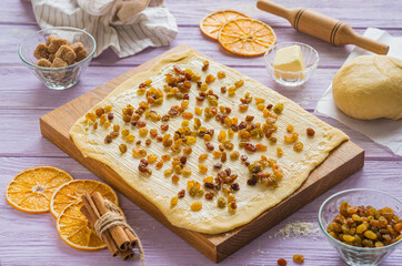Step-by-step cooking of kraffin (cruffin), yeast Easter cake with raisins. Step three, sprinkle raisins on the rolled out dough