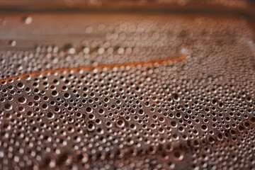 small drops of water on a beige background in close-up