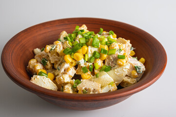 Salad with grilled chicken fillet, breadcrumbs, quail eggs, corn on a clay plate isolated on a white background. Selective focus. The concept of delicious spring salads