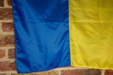 Flag of Ukraine, a great national symbol on a brick background. Big yellow and blue Ukrainian state flag Independence Constitution Day, National holiday.