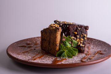 Pancake chocolate cake with nuts, honey cake on a brown clay plate isolated on a white background. High quality photo