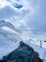 road in the snow between snowy mountains