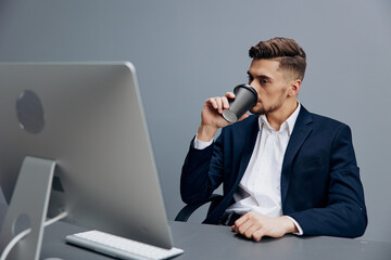 handsome businessman tired glass of coffee works in front of a computer office