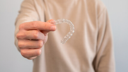Man holds invisalign transparent braces for dental correction. Dentist office - obrazy, fototapety, plakaty