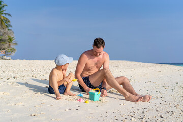 Father and son play on the beach in Maldives. International Father's Day