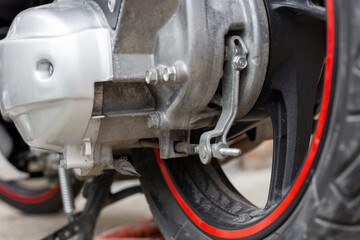 The rear wheel of a motorbike with a gearbox, a brake mechanism and a variator housing. Motorcycle repair.