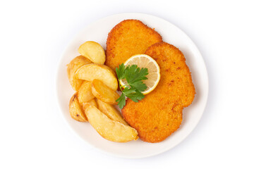 Chicken schnitzel with sauce, fried potatoes and lemon in a plate