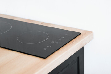 Small glass ceramic induction hob with two burners at wooden countertop