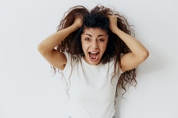 Naklejka premium Panic Attack PROBLEMS CONCEPT. Crazy beautiful Latin female with afro rips out hair, have big troubles. Fashion. Studio shoot over white background. Copy space, free place for design ad. 