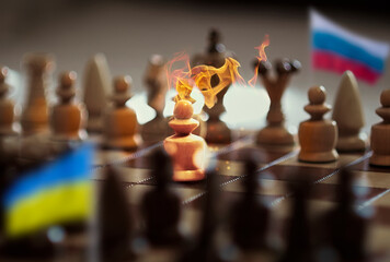 Flags of Ukraine and Russia. Chess pieces on a chessboard. Fire and sparks. The concept of conflict. Concept collage.