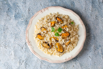 Mussel rice pilaf. Rice with mussels on small white plate on ceramic. (Turkish name; midyeli pilav)