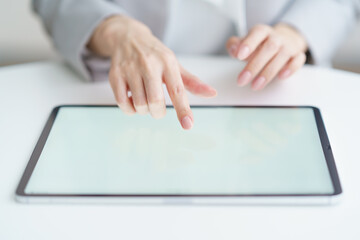 Hands of a woman operating a tablet PC