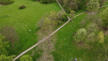 Aerial shot of a beautiful green park with walking trails and benches