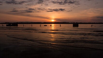 Fototapeta na wymiar Sunset over the Volga river. Samara riverport is flooded by the spring high water. Russia.