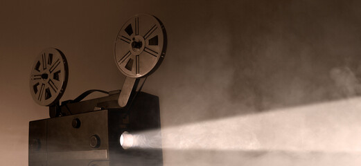 Naklejka premium Old vintage 8mm projector with film reels and film frames. Copy space. Selective focus.