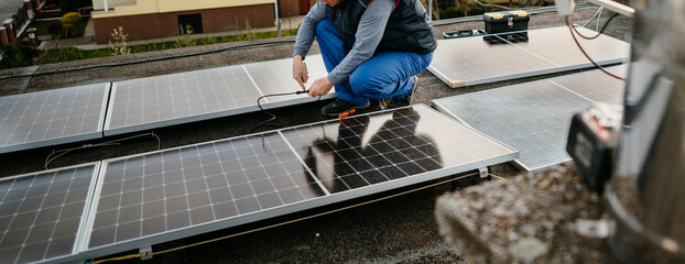Worker installing new solar panels on roof of family house. Alternative energy. Cover photo