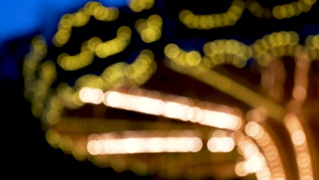 Blurred carousel spin and glow with lights in twilight dusk. Childhood in amusement park, playground