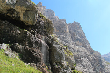 Fototapeta na wymiar Mountain landscape in a sunny day. Waterfall stream in Italian Alps.