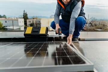 Engineer installing solar photovoltaic panel system using screwdriver. Alternative energy concept