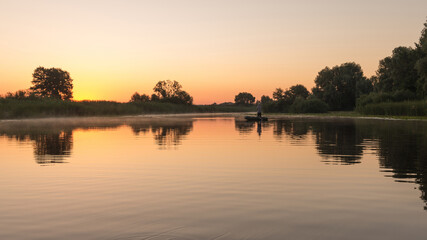 Obraz na płótnie Canvas Fishermen on rubber boat early morning in river. Rural landscape.