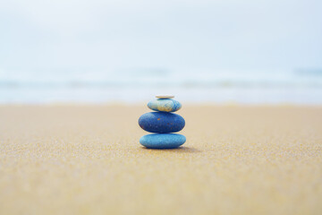 Fototapeta na wymiar Pyramid of stones on the beach. Tranquil scene, relaxation, seaside vacation, meditation concept